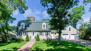 A two-story house with a front porch, a garage, and a well-maintained lawn.