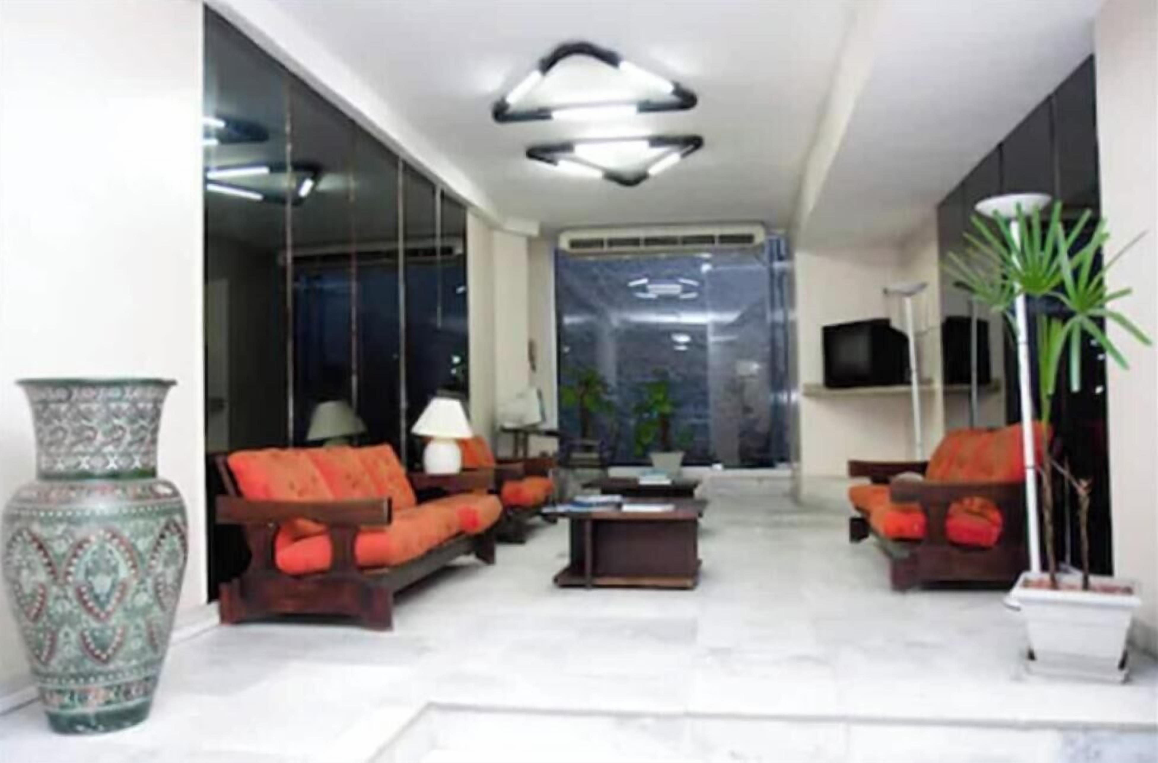 A modern living room with a sofa set, a coffee table, a decorative vase, and a television.