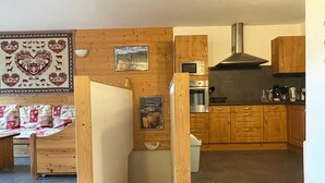 Eine moderne Küche mit Holzausstattung, einer Edelstahl-Dunstabzugshaube und einer Mikrowelle.
