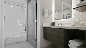A modern bathroom with a walk-in shower, a toilet, and a vanity with a mirror. - Staybridge Suites Atlanta Ne - Duluth by IHG (Duluth)