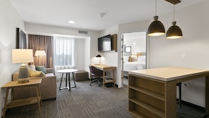 A hotel room with a sofa, desk, chair, and a bed. - Staybridge Suites Atlanta Ne - Duluth by IHG (Duluth)