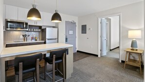A modern kitchen with a central island, bar stools, and pendant lighting. - Staybridge Suites Atlanta Ne - Duluth by IHG (Duluth)