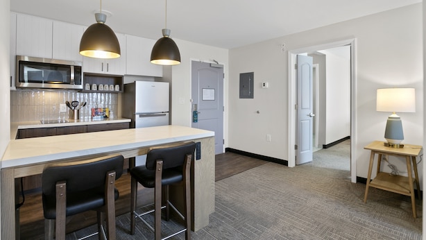 A modern kitchen with a central island, bar stools, and pendant lighting. - Staybridge Suites Atlanta Ne - Duluth by IHG (Duluth)