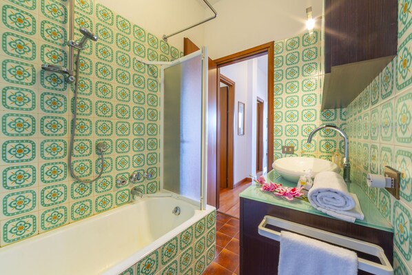 Een bad/douchecombinatie, een haardroger, een bidet, handdoeken