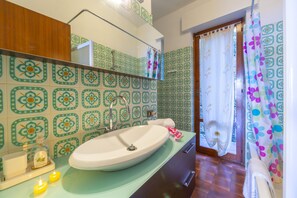 Een bad/douchecombinatie, een haardroger, een bidet, handdoeken