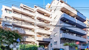 A multi-story residential building with balconies, a parking sign, and a pedestrian crossing sign. - GrandTree Yokohama Station (Yokohama)
