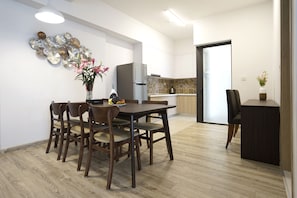 Una cocina moderna con comedor, piso de madera y un elemento decorativo en la pared.