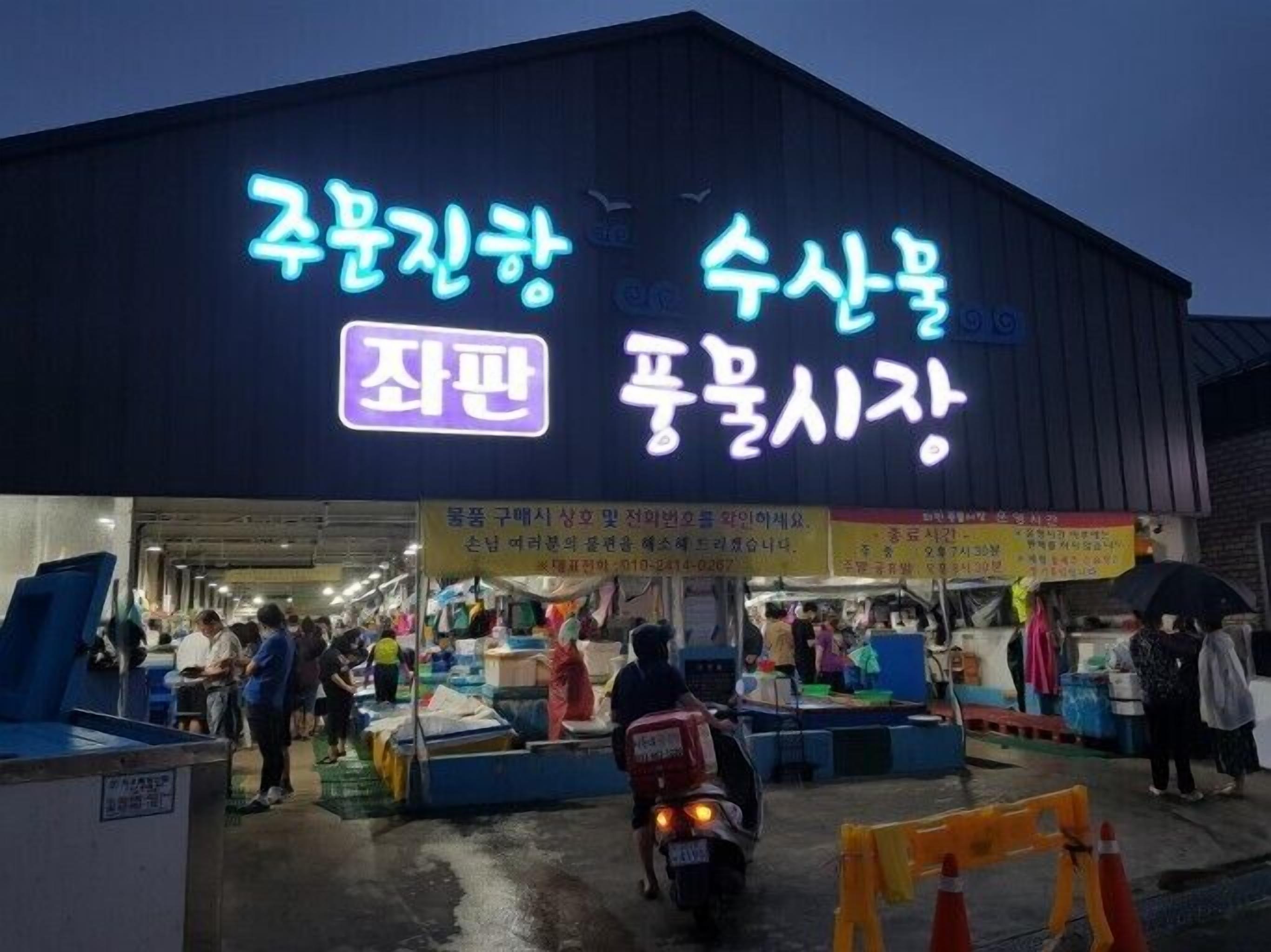 A market with various stalls and people shopping.