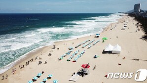 A beach with rows of umbrellas and tents, a lifeguard tower, and a clear view of the ocean. - Benikea San & Bada Jumunjin Resort (Gangneung)