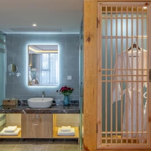 Un baño moderno con un espejo grande, un lavabo y una puerta de madera con diseño de cuadrícula.