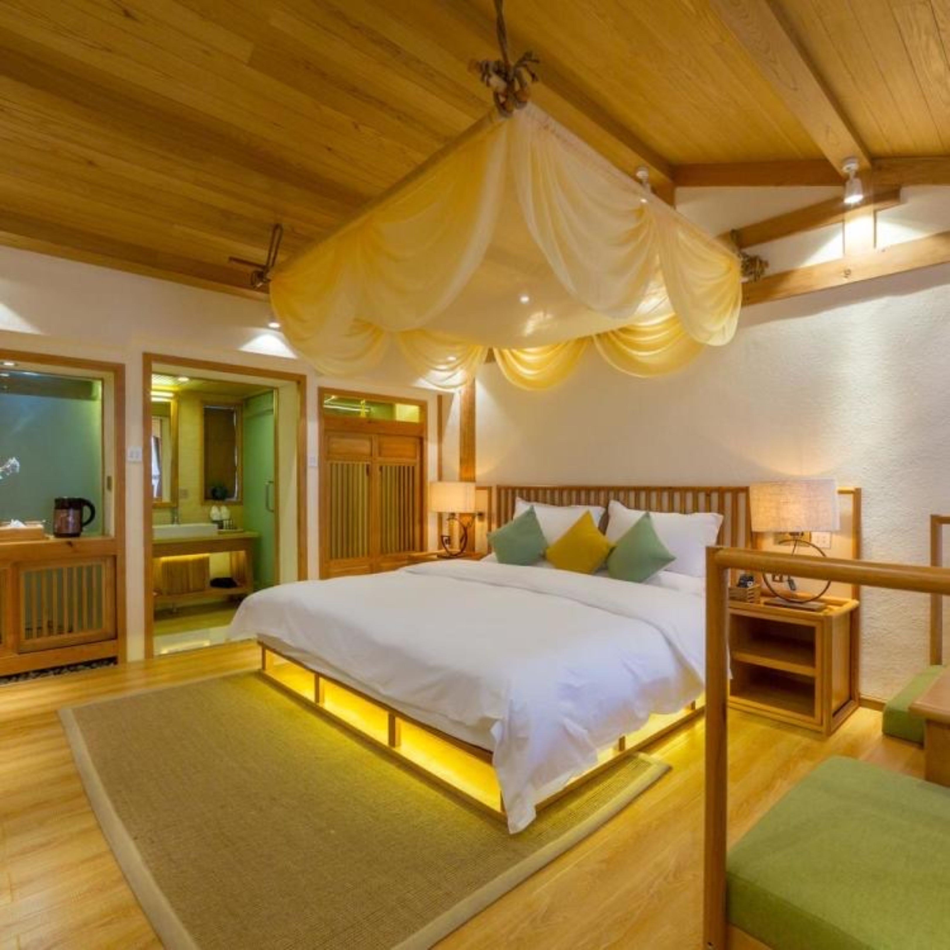 Una habitación con cama, mesita de noche y espejo.