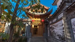 A traditional building with a tiled roof, a wooden door, and a staircase leading to the entrance.