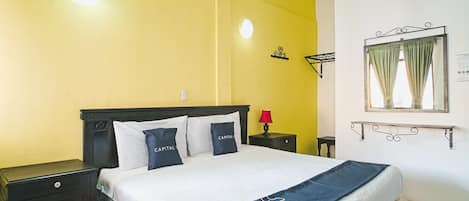 A bedroom with a bed, nightstands, a mirror, and a wall-mounted shelf.