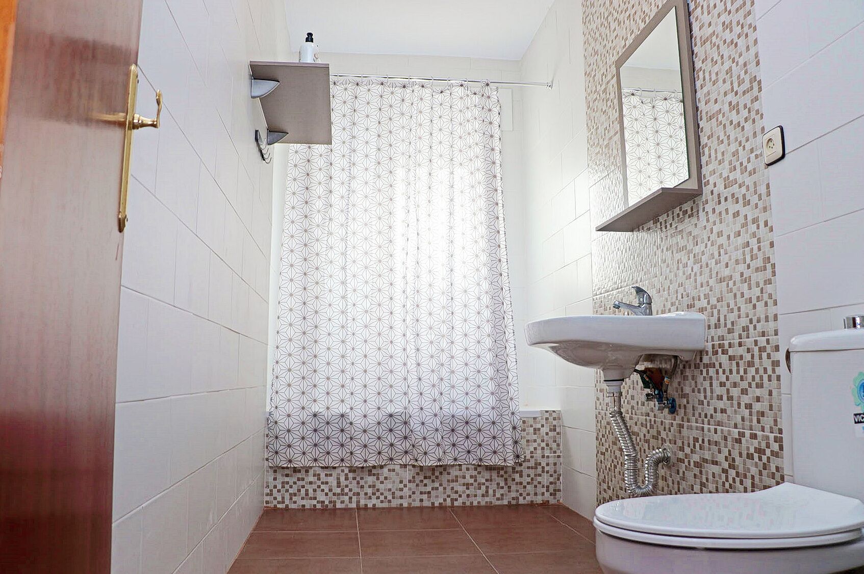 Une salle de bain avec une douche, un lavabo et des toilettes.