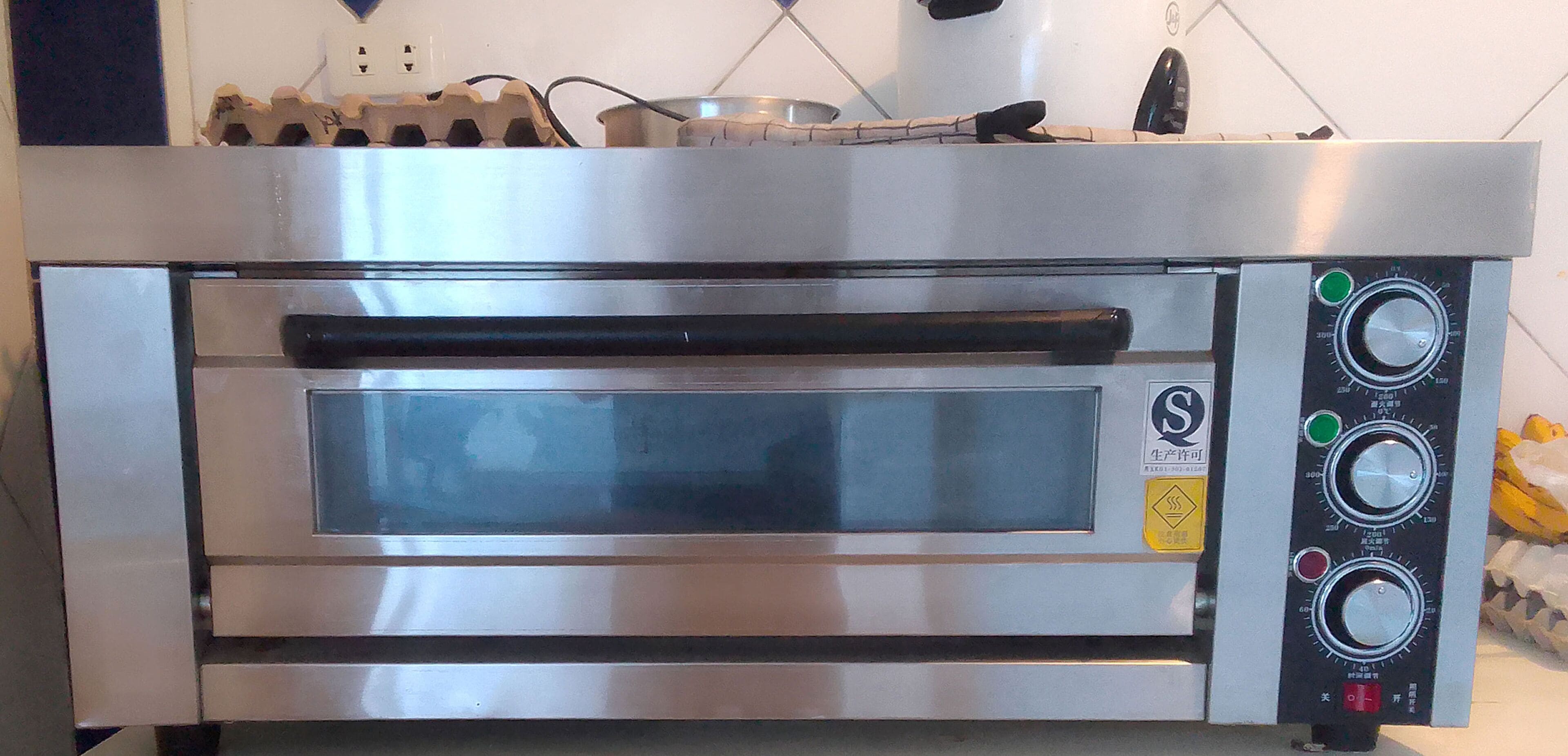 Un forno professionale in acciaio inossidabile, dotato di display digitale e manopole di controllo.