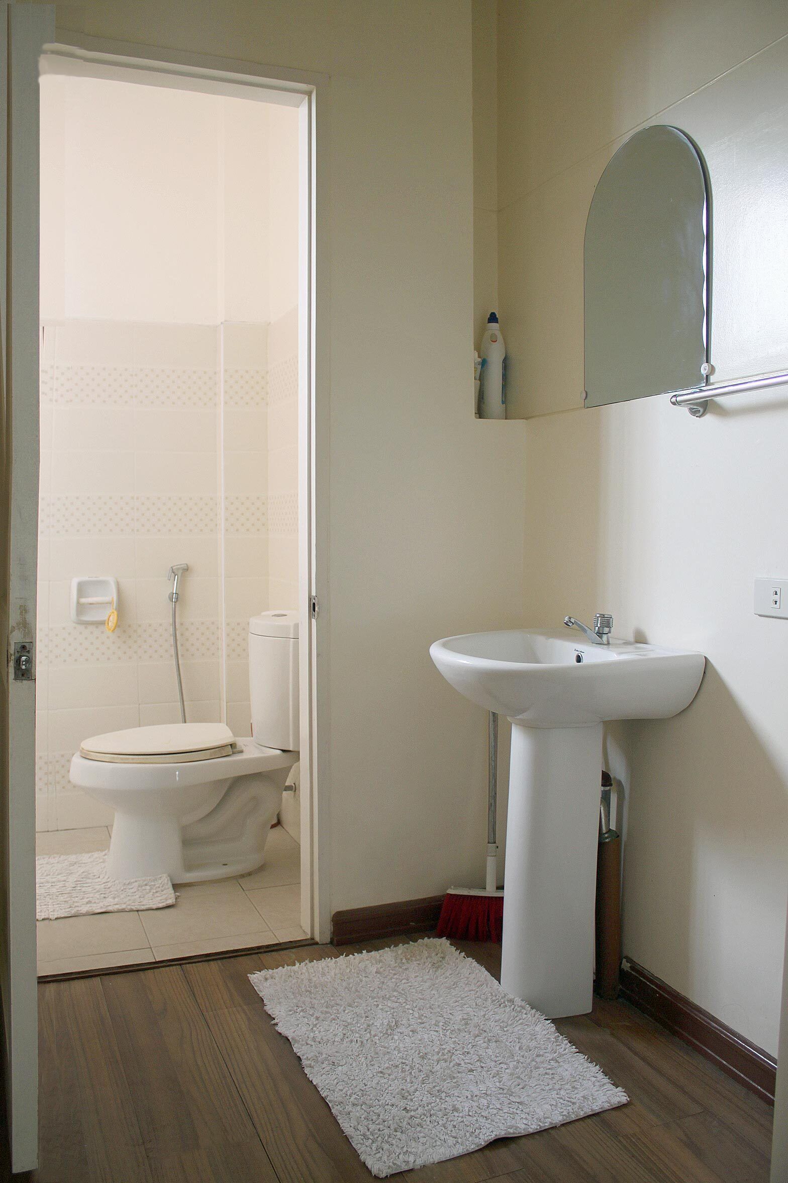A bathroom with a toilet, sink, and shower.