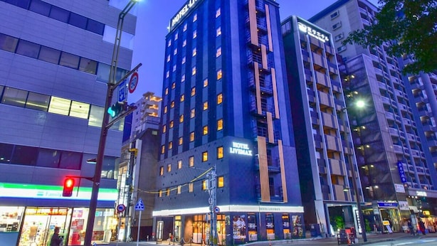 A multi-story hotel with a prominent 'HOTEL LIVENMAX' sign, featuring a modern architectural design with balconies and large windows. - Hotel Livemax Hakata Nakasu (Fukuoka)