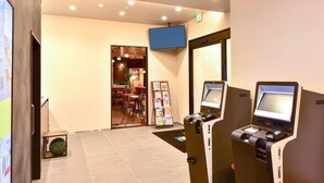 A hotel lobby with a reception area, a seating area, and a vending machine. - Hotel Livemax Hakata Nakasu (Fukuoka)