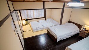A traditional Japanese-style room with tatami flooring, a shoji screen, and a bed with white bedding. - Kyokoi Reishikamogawa (Kyoto)