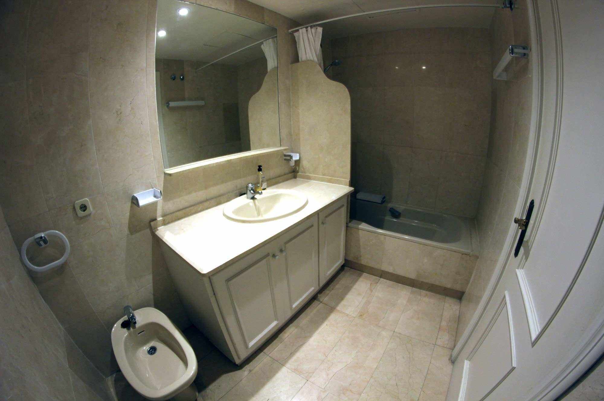 Une salle de bain équipée d’un lavabo, d’un miroir, d’une douche et d’un bidet.