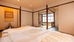 A traditional Japanese room with tatami flooring, a large bed with white bedding, a sliding door leading to a balcony, and a framed artwork on the wall. - Kyokoi Kiyomizu (Kyoto)