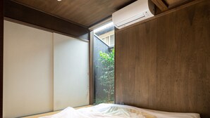 A bedroom with a large bed, wooden ceiling, and an air conditioning unit. - Kyokoi Kiyomizu (Kyoto)