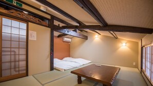 A traditional Japanese room with tatami flooring, a low wooden table, and a futon bed. - Kyokoi Kiyomizusaryou (Kyoto)