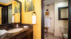 A bathroom with a marble sink, a white toilet, and two wall-mounted mirrors.