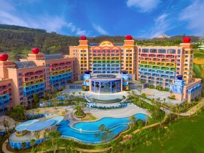 A multi-story hotel with a central pool area, multiple balconies, and a landscaped garden. - Dolphin Bay Hotel (Yuxi)