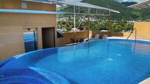 A rooftop swimming pool with a clear view of a cityscape and mountains in the background. - Fabuloso Hotel Las Vegas (Zihuatanejo)