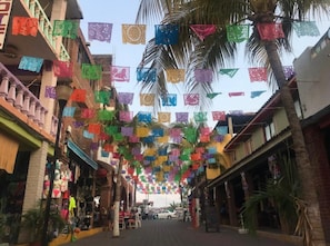 A street lined with buildings, decorated with colorful paper flags. - Fabuloso Hotel Las Vegas (Zihuatanejo)