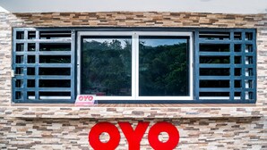 Fachada de edificio con un gran letrero 'OYO' en letras rojas.