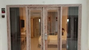 Una habitación con una puerta corrediza de vidrio que da a un dormitorio.