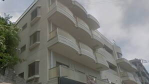 A multi-story building with balconies, a gated entrance, and a sign indicating a business or commercial use. - GrandTree ATAMI KAIKO-INN (Atami)