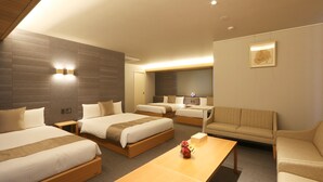 Een hotelkamer met twee bedden, een bank, een bureau en een kleine tafel met een vaas.