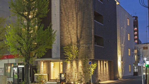 Een hotel met een modern ontwerp, met een opvallende ingang en meerdere balkons.
