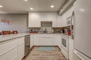 A kitchen with white cabinets, a microwave, and a dishwasher.
