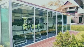 A modern building with large glass windows and a wooden deck area.