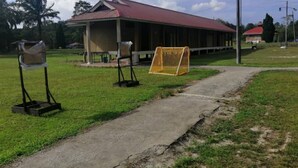 A covered pavilion with a red roof, a concrete pathway, and a soccer goal. - Hotel O Otternest @ Gunung Pulai 2 (Pekan Nanas)