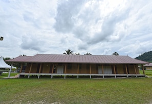 A single-story building with a flat roof, a porch with white railings, and a series of doors on the front side. - Hotel O Otternest @ Gunung Pulai 2 (Pekan Nanas)