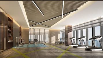 Un gimnasio moderno con equipo de ejercicio, ventanas amplias y un techo alto.