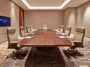 A conference room with a long table, beige chairs, and a pullman sign on the wall.