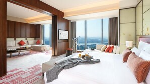 A modern hotel room with a large bed, a sofa, a desk, and a view of the city. - Pullman Huizhou Kaisa (Huizhou)