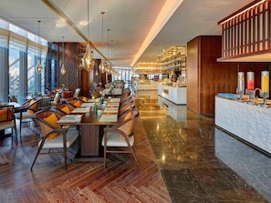 A spacious dining area with high ceilings, modern chandeliers, and a central island with a bar. - Pullman Huizhou Kaisa (Huizhou)
