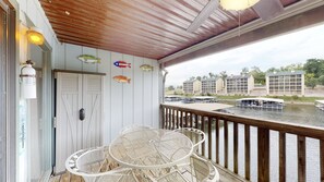 Una terraza de madera con muebles de mimbre blanco y peces decorativos.