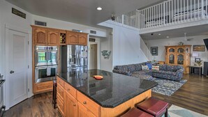 A spacious kitchen with a large island, wooden cabinets, and stainless steel appliances. - Bayfront Fishing Pier: Galveston Island Home! (Galveston)
