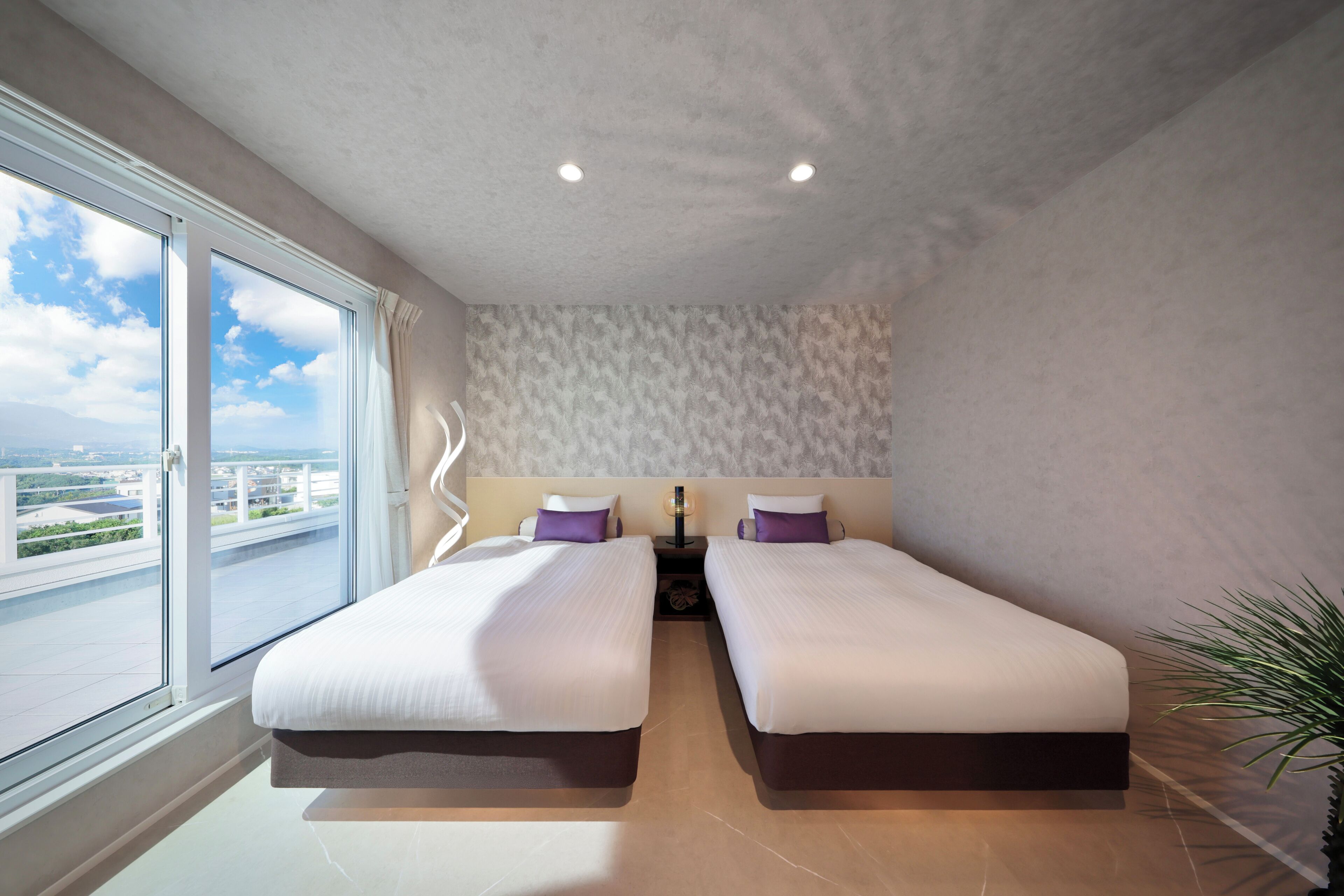 Un dormitorio moderno con dos camas, un ventanal con vista a la ciudad y una pared con diseño.