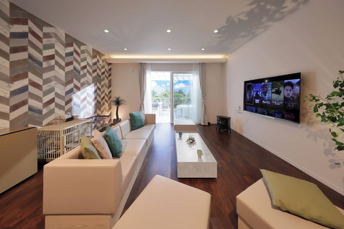 A modern living room with a sofa, coffee table, and a television mounted on the wall.