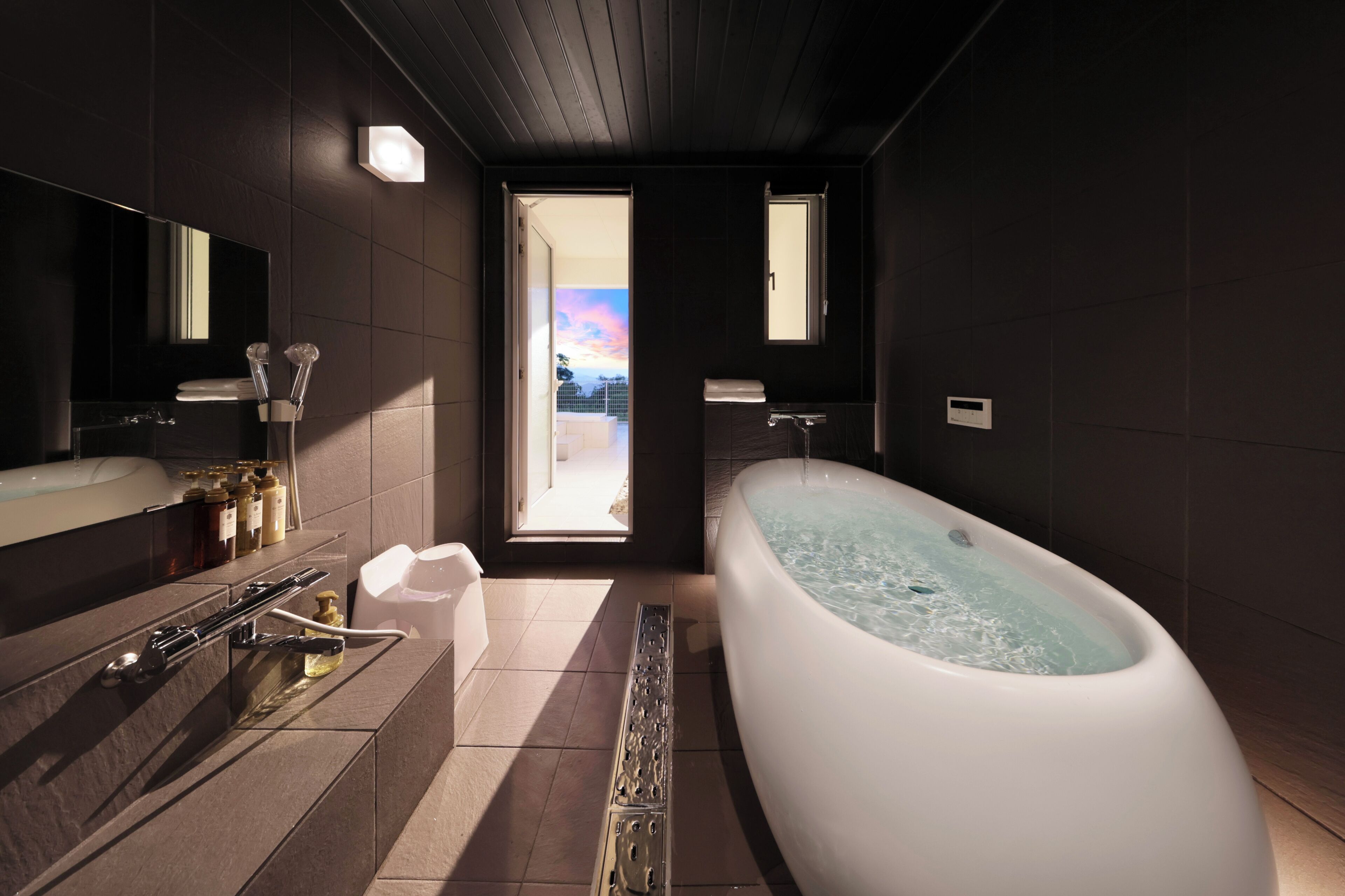 Un baño moderno con una bañera grande, una zona de ducha separada y un tocador con artículos de aseo.