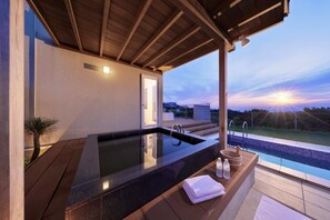 A spa area with a hot tub, wooden deck, and a view of the sunset. - Crystal Villa SHIRAHAMA (Shirahama)